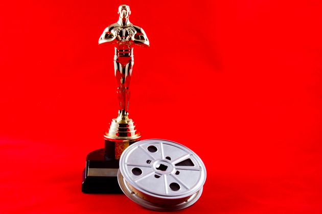 New Cumberland, PA, USA - February 3, 2015 : Illustrative editorial showing the Academy Awards statue known as Oscar with an old time movie reel on the iconic red carpet