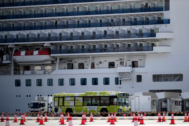 A bus carrying passengers leave the port after passengers disembarked from the quarantined Diamond Princess cruise ship Wednesday, Feb. 19, 2020, in Yokohama, near Tokyo. Passengers tested negative for COVID-19 started disembarking Wednesday. (AP Photo/Jae C. Hong)