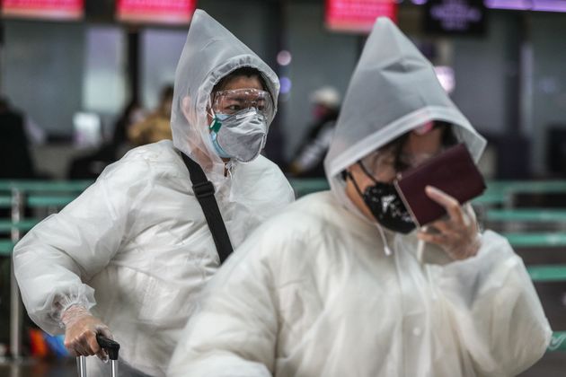 26일 오후 인천국제공항 제1터미널에서 코로나19 예방을 위해 비닐옷과 마스크를 착용한 여행객이 출국장으로 향하고 있다. 