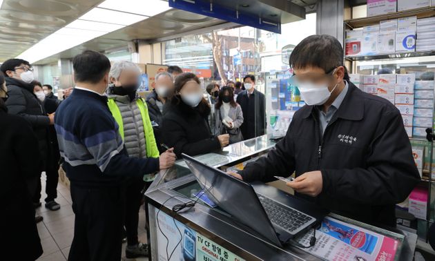 6일 오전 서울 종로5가 인근 약국에서 약사가 시민의 주민등록증을 등록하고 있다.