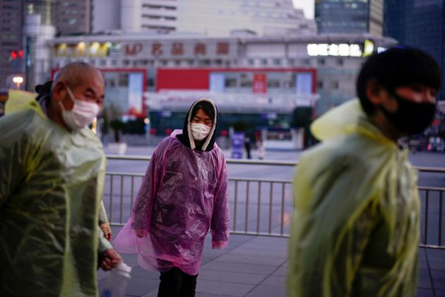 상하이 기차역 인근에서 비닐 비옷과 마스크로 '무장'한 시민들이 거리를 걷고 있다. 2020년 3월5일.