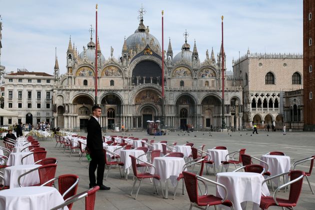 이탈리아 베네치아 산마르코광장의 한 레스토랑에서 한 직원이 텅 빈 테이블을 바라보고 있다. 이탈리아 정부는 10일부터 전국으로 이동금지령을 확대한다고 밝혔다. 베네치아, 이탈리아. 2020년 3월9일.