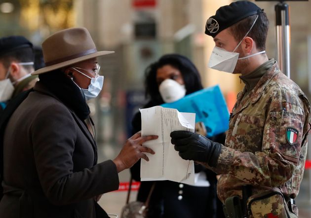 경찰관과 군인들이 밀라노 기차역에서 출발하려는 승객들을 대상으로 검문을 실시하고 있다. 밀라노, 이탈리아. 2020년 3월9일.