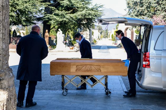 이탈리아 북부 롬바르디아주의 도시 베르가모 기념묘지에서 장의사들이 영구차에서 관을 꺼내 옮기고 있다. 2020년 3월16일.