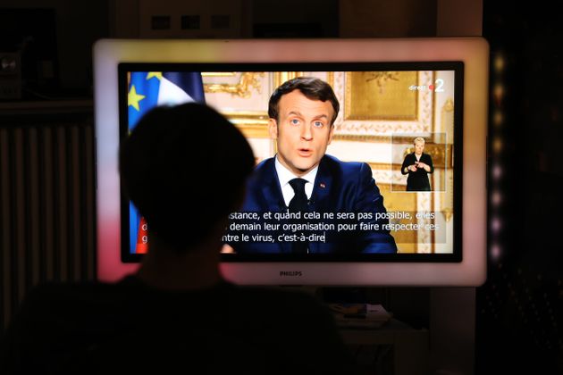 한 시민이 에마뉘엘 마크롱의 대국민 기자회견을 시청하고 있다. 파리, 프랑스. 2020년 3월16일.