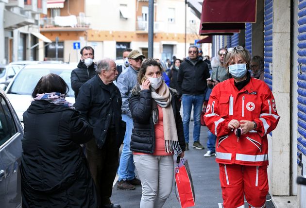 손수 만든 마스크를 무료로 배포하겠다고 공지한 한 가게 앞에서 사람들이 줄을 서고 있다. 그로세토, 이탈리아. 2020년 3월17일.