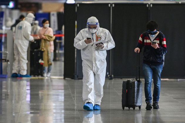 상하이 푸동 국제공항에서 보호복을 입은 공항 보안요원이 한 입국 승객을 안내하고 있다. 2020년 3월26일.