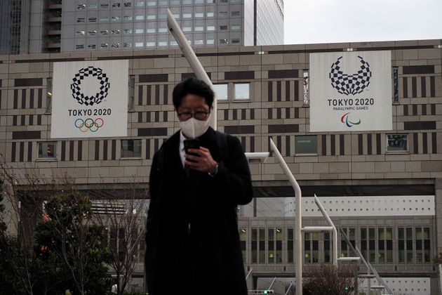 마스크를 쓴 한 남성이 도쿄도 청사 건물을 지나고 있다. 