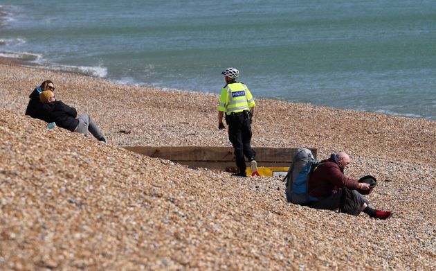 경찰이 해변에서 휴식을 취하는 사람들에게 귀가를 요청하고 있다. 브라이튼, 영국. 2020년 3월28일.