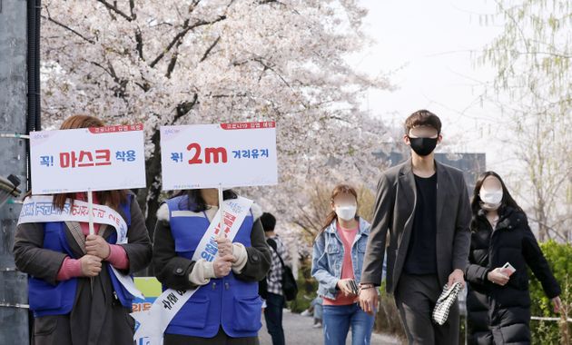 서울 영등포구 여의나루역 인근에서 영등포구청 직원들이 마스크 착용과 2m 거리두기 팻말을 들고 코로나19 예방 캠페인을 하고 있다. 2020년 4월6일.