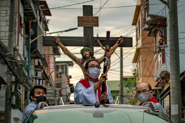 10일 필리핀 마닐라의 한 거리에서 예수상을 든 신부가 트럭을 타고 이동제한령이 내려진 주거지를 돌고 있다. 필리핀은 인구의 대부분이 천주교 신자인 것으로 유명한 나라지만 올해만큼은 거의 모든 부활절 행사들이 취소됐다. 