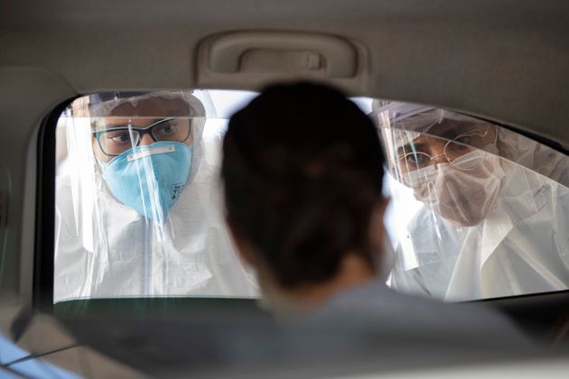 보호복을 착용한 의료진들이 통행자들의 코로나19 증상 여부를 검사하고 있다. 상파울루, 브라질. 2020년 3월30일.