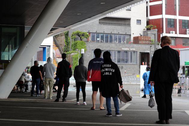 15일 오전 서울 용산구 한남동 공영주차장에 마련된 도보형 이동형(워킹스루) 선별진료소를 찾은 시민들이 문진표 작성을 하기 위해 줄을 서 있다.