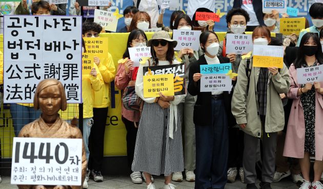 20일 오후 서울 종로구 옛 일본대사관 앞 평화의 소녀상 앞에서 열린 제1440차 일본 성노예제 문제해결을 위한 수요집회에서 참가자들이 손 피켓을 들고 있다.