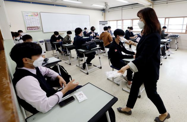 20일 오전 서울 시내의 한 고등학교 3학년 학생들이 교실에서 담임 선생님에게 방역 물품을 받고 있다.