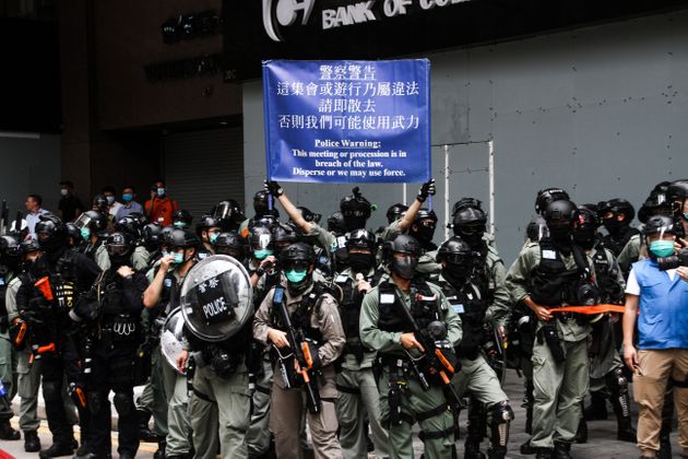 경찰이 홍콩 시위대에게 경고 내용이 담긴 현수막을 들어 보이고 있다. 홍콩 센트럴 섬. 2020. 5. 27.
