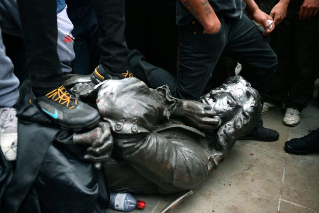 한 시위자가 끌어내려진 동상의 목을 무릎으로 누르고 있다. 브리스톨, 영국. 2020년 6월7일.
