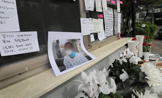고 최희석씨가 근무했던 경비실 앞에 그의 사진과 함께 국화꽃이 놓여있다.