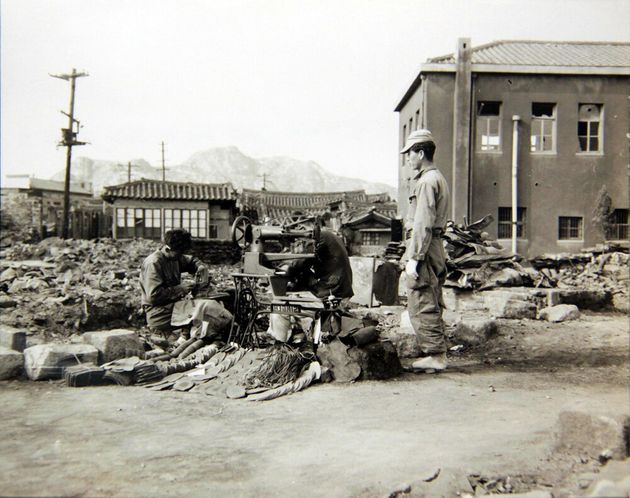 1950년 10월 28일 서울 수복 후, 한 수선공이 자기 가게가 있던 자리에서 다시 영업을 하며 전투화를 수선하는 모습. 2018년 6월 22일 공개.