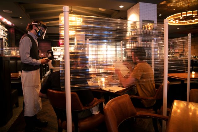 6월 22일 미국 LA의 Water Grill 식당에서 식탁마다 칸막이를 쳐두고 서버는 얼굴 보호장구를 착용한 모습.