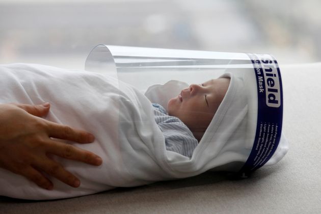 4월 13일 베트남 하노이에서 신생아 푹 안이 얼굴 보호장구를 착용하고 있다.