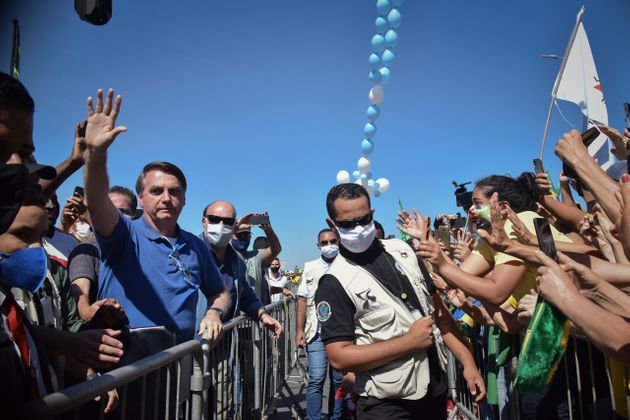 (자료사진) 자이르 보우소나루 브라질 대통령은 코로나19의 위험성을 일축해왔다. 사진은 그가 지난 5월 마스크를 쓰지 않은 채 대통령궁 바깥에 모인 지지자들에게 손을 흔들고 있는 모습. 브라질리아, 브라질. 2020년 5월31일.