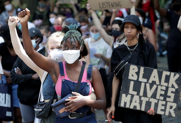 Two young woman take part in a Black Lives matter anti-racism protest rally in Berlin, Germany, Saturday, June 27, 2020. (AP Photo/Michael Sohn)