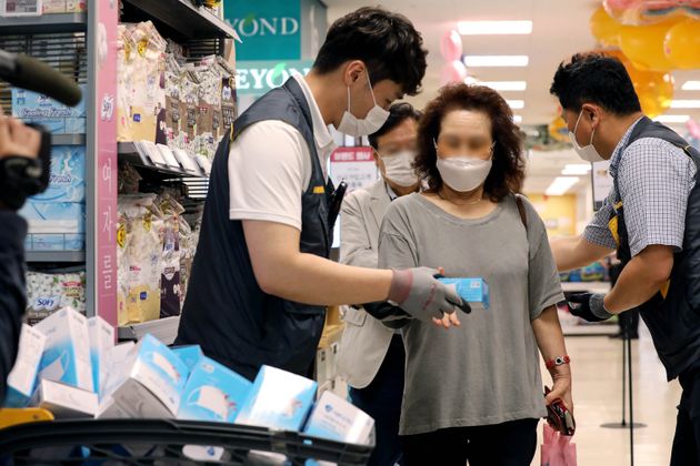 지난 24일 오후 서울 성동구 이마트 성수점에서 비말 차단용 마스크를 구매하려는 시민들이 번호표와 마스크를 맞바꾸고 있다