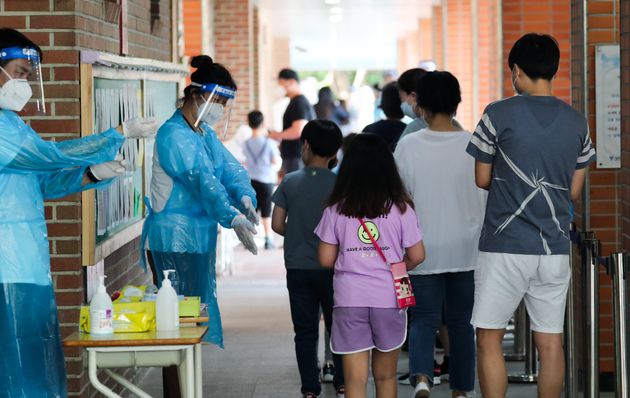 서울 중랑구의 묵현초등학교 학생 1명이 신종 코로나바이러스 감염증(코로나19) 확진 판정을 받은 5일 묵현초에 마련된 선별진료소에서 학생들이 전수검사를 기다리고 있다.