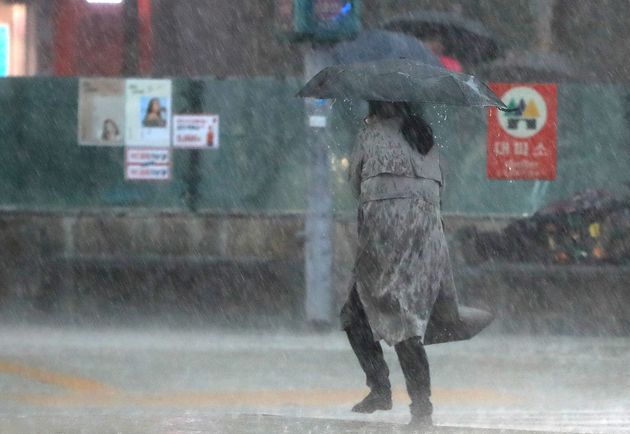 지난 5월 서울 광화문네거리에서 시민들이 갑자기 내린 폭우에 발걸음을 옮기고 있다