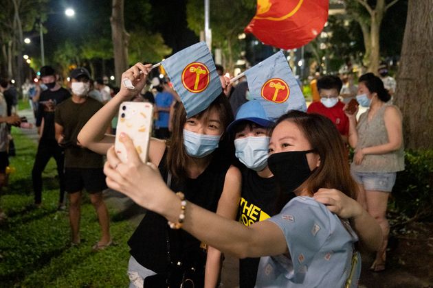 싱가포르 야당 노동자당의 지지자들이 총선 출구조사 결과 발표에 환호하며 사진을 찍고 있다. 2020년 7월11일.