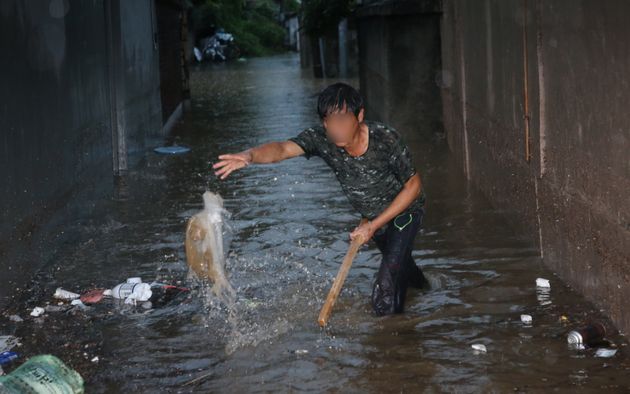 대전지역에 호우경보가 발효된 30일 오전 대전 동구 대동 주택가에서 시민이 하수구를 막고 있는 쓰레기를 치우고 있다