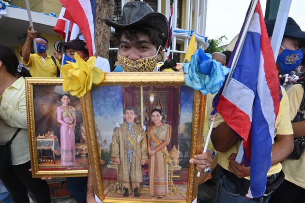 현 왕실을 지지하는 이들 역시 맞불 시위를 열고 있다. 16일 방콕에서 열린 친왕실집회 참가자가 왕과 왕비의 사진을 들고 있는 모습.