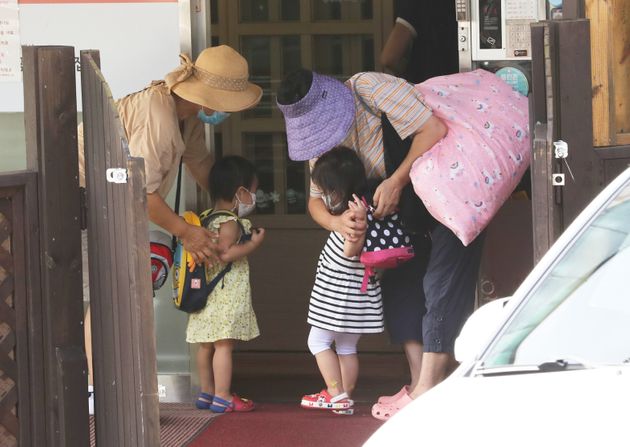 신종 코로나바이러스 감염증(코로나19) 재확산으로 사회적 거리두기가 2단계로 격상된 가운데 25일 서울 종로구의 한 국공립어린이집에서 할머니들이 자녀를 긴급돌봄교실에 등원 시키고 있다.