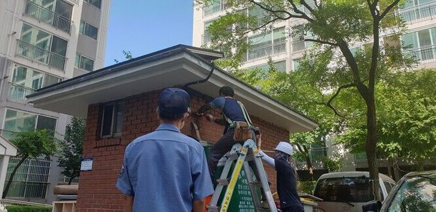 지난 25일 설비업체 직원들이 대전 대덕구 한 아파트 경비실에 미니태양광 시설을 설치하는 모습을 이 아파트 경비원이 바라보고 있다.