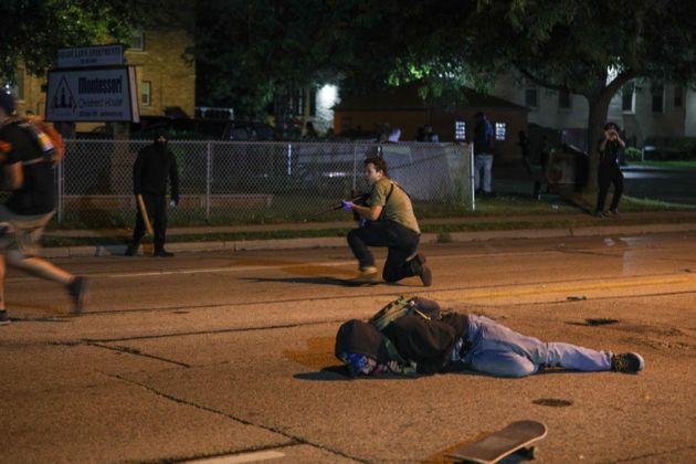 시위대와 무장한 자경단원들이 충돌한 가운데 한 남성이 총에 맞아 쓰러져있다. 사진 속에서 총을 든 백인 남성은 총을 발사해 두 명을 숨지게 한 혐의로 체포됐다. 커노샤, 위스콘신주. 2020년 8월25일.