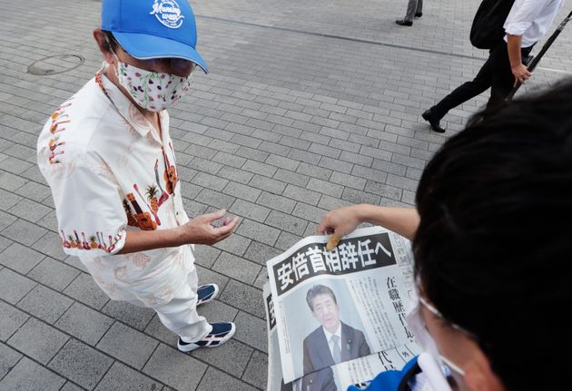 아베 총리의 사임 뉴스를 실은 아사히 호외판을 받아드는 일본 시민의 모습 