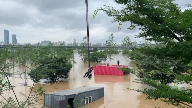 8월3일 오후 서초구 한강시민공원 잠원지구에서 컨테이너 이동 작업 중이던 인부 2명이 불어난 물에 고립돼 소방대원들이 구조하고 있다.