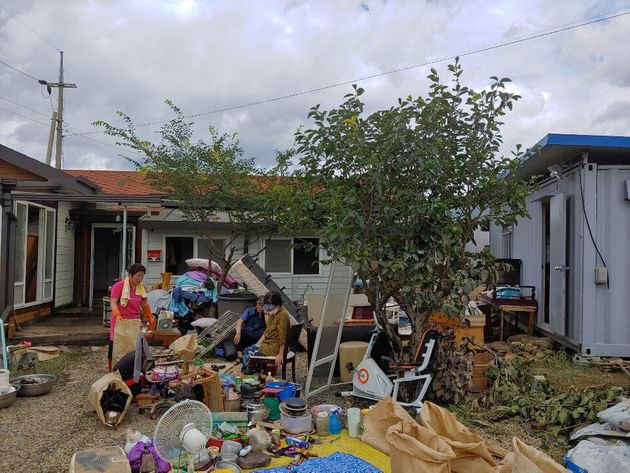 9일 오후 전남 구례군 한 마을에서 마을 주민들이 침수 피해를 입은 집을 복구하다 지쳐 앉아있다.
