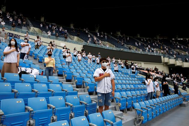 프로야구 LG 트윈스 대 두산 베어스의 경기가 열린 서울 잠실야구장에서 관중들이 사회적 거리두기를 한 채 국민의례에 임하고 있다. 2020년 7월26일.