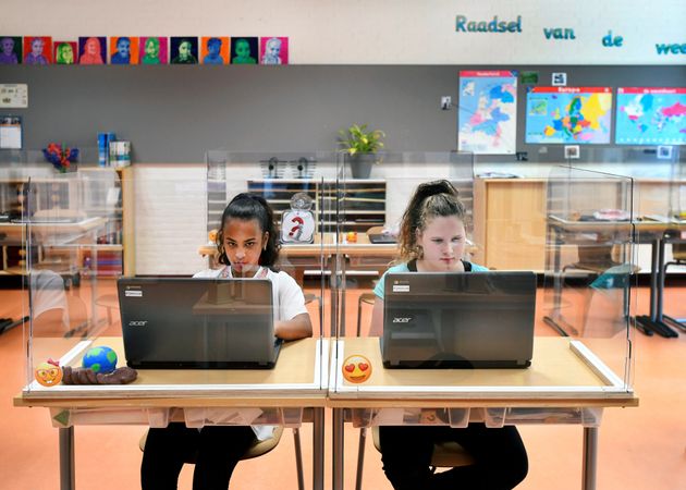 플라스틱 칸막이로 '격리'된 채 수업을 듣고 있는 학생들. 덴보스, 네덜란드. 2020년 5월8일.