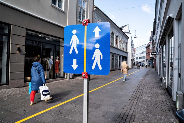 사람들이 길을 걷다가 서로 마주치지 않도록 보행로 한 가운데에 노란색 중앙선이 그려졌다. 올보르그, 덴마크. 2020년 5월4일.