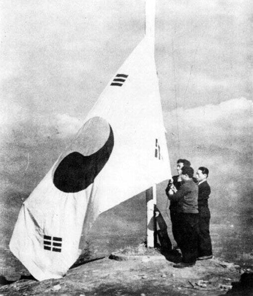 1945년 8월 15일 해방을 맞아 서울 시민들이 남산에 처음으로 태극기를 게양하는 모습.