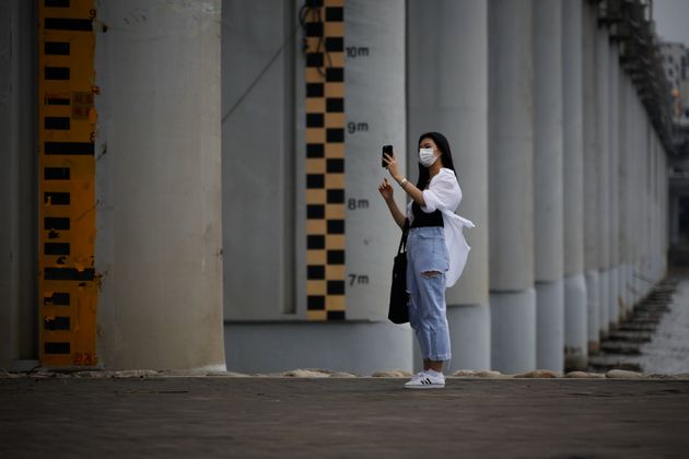 (자료사진) 마스크를 쓴 여성이 홍수계 앞에서 사진을 찍고 있다. 2020.8.27