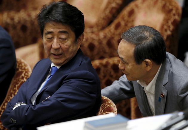 (자료사진) 중의원(하원) 회의에 참석한 아베 신조 일본 총리가 스가 요시히데 관방장관과 대화를 나누고 있다. 도쿄, 일본. 2015년 7월15일.