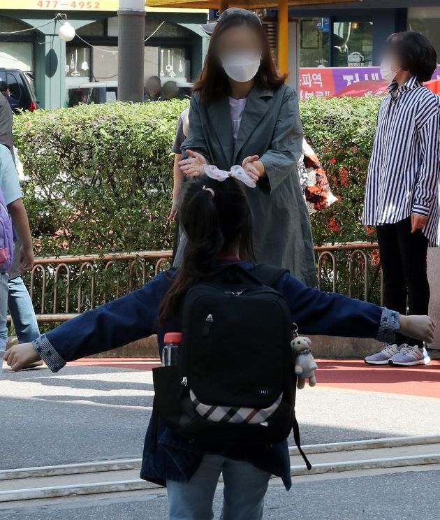 수도권의 유치원과 초·중·고등학교 등교가 재개된 21일 오전 서울 강동구 한산초등학교에서 수업을 마친 한 초등학생이 달려가 엄마품에 안기고 있다.