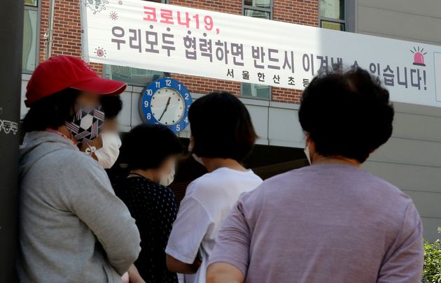 수도권의 유치원과 초·중·고등학교 등교가 재개된 21일 오전 서울 강동구 한산초등학교 교문 앞에서 학부모들이 수업을 마친 학생들을 기다리고 있다.