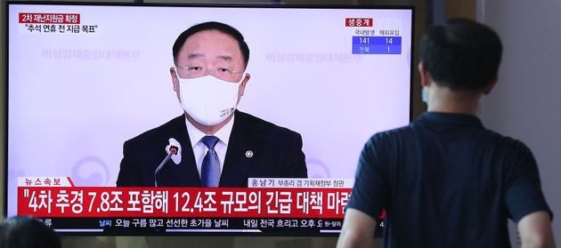 10일 오후 서울 중구 서울역에서 한 시민이 2차 긴급재난지원금 지급 관련 뉴스를 지켜보고 있다. 