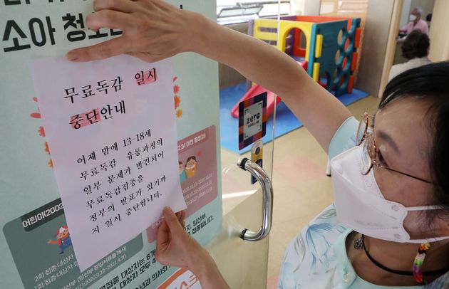 22일 오전 서울 송파구의 한 소아병원에서 간호사가 무료독감 일시중단 안내문을 붙이고 있다.  