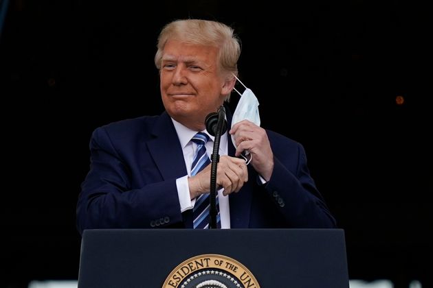 도널드 트럼프 미국 대통령이 백악관 발코니에서 지지자들을 상대로 연설을 하기에 앞서 마스크를 벗고 있다. 2020년 10월10일.